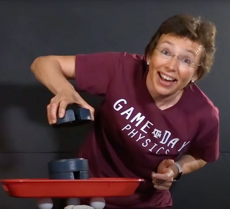 Dr. Tatiana holding a 2 kg weight over several eggs as an experiment.