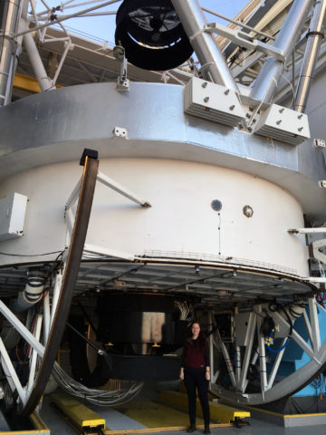 Hutchison, posing with the 6.5-meter Multiple Mirror Telescope (MMT) at the Smithsonian's Fred Lawrence Whipple Observatory in Arizona.