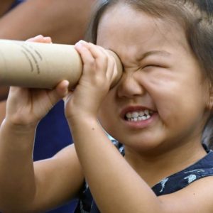Picture of little girl looking through a telescope