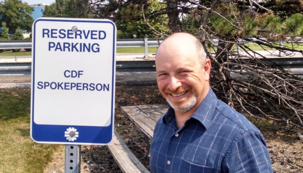 David Toback in front of a sign that reads "Reserved Parking: CDF Spokesperson"