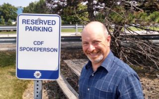 David Toback in front of a sign that reads "Reserved Parking: CDF Spokesperson"