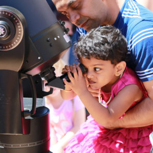 Girl looking through telescope