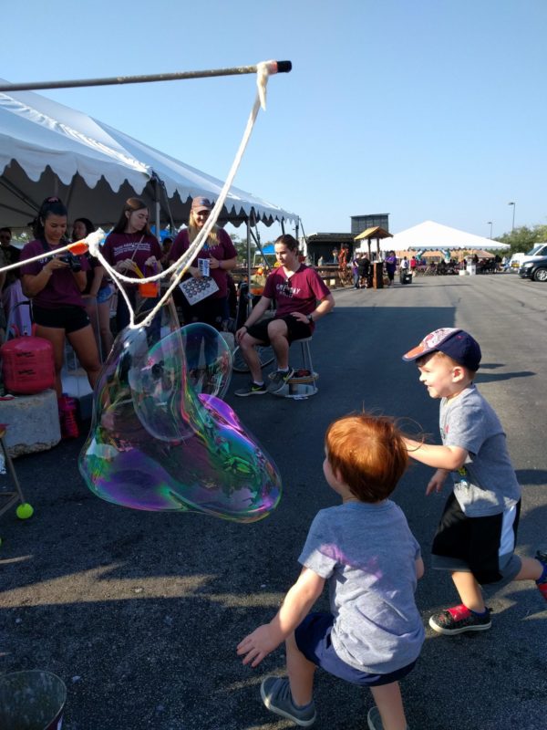 Two little boys chase giant bubbles at the Boonville Days event.