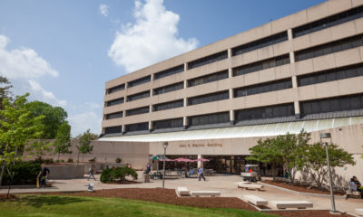 John R. Blocker building on a sunny day with guests walking out front.